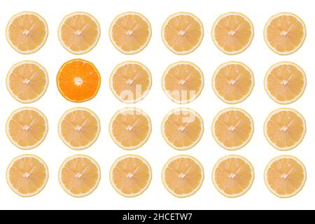 Several rows of lemon fruit slices and only one orange slice isolated on a white background Stock Photo