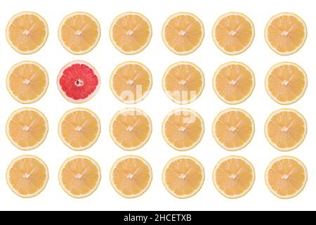 Rows of lemon fruit slices and only one grapefruit slice isolated on a white background Stock Photo
