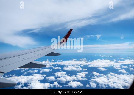 Classic image through aircraft window onto wing. Flight view over clouds Stock Photo