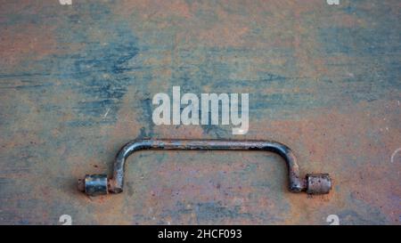 Old rusty metal handle on a grungy surface Stock Photo