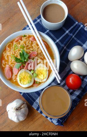 Photo of noodle soup with toppings such as sausages, eggs, and vegetables Stock Photo