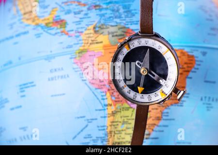 Compass on top of world map. Magnetic compass on world map. Stock Photo