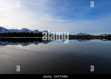 the hopfensee at sunrise with reflection of the mountains in the water Stock Photo