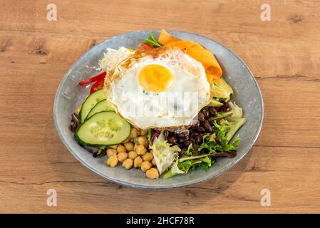 Power salad with black beans, kale, chickpeas, fried egg and cucumbers and carrots with avocado and cooked white rice Stock Photo