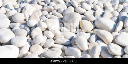 Small stone texture background. Pattern of white gray smooth seaside pebbles. Top view Stock Photo
