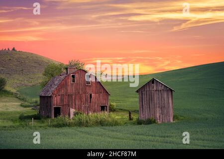 Rural farm scene at sunset with red barn viewed from the Palouse in Washington state Stock Photo