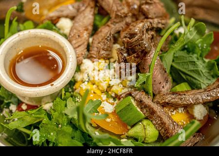 Closeup of a delicious salad with veggies and slices of roasted beef in a metal container Stock Photo