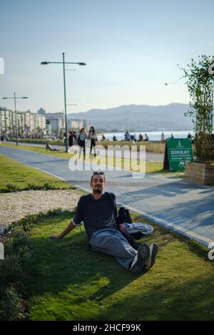 Happy looking man lying on the grass while posing for a picture Stock Photo