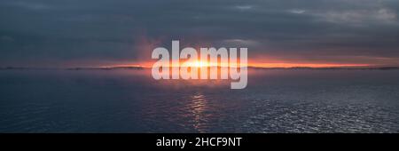 Dramatic view of bright sunset over the sea Stock Photo