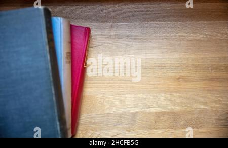 Books stack on a table. Closed old notebooks on wooden desk background, top view. Copy space, template Stock Photo