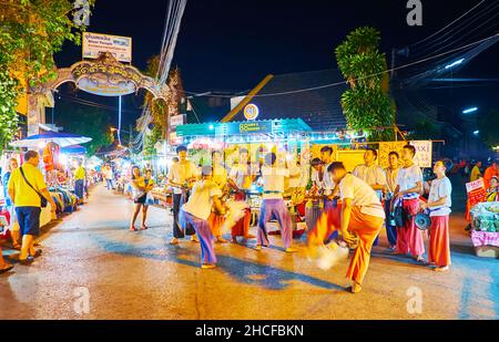 CHIANG MAI, THAILAND - MAY 4, 2019: Two young artists perform ritual battle dance, while musicians play drums at Saturday Night Market in Wualai walki Stock Photo