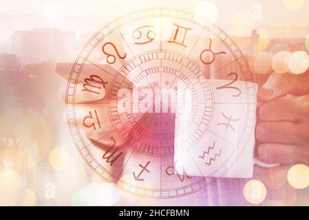 Astrology smartphone app, man drinking coffee and reading horoscope and astrological predictions on mobile phone, selective focus Stock Photo