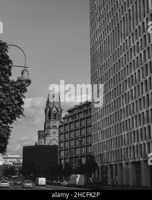 Vertical grayscale shot of the Kurfurstendamm church and modern buildings in Berlin, Germany Stock Photo