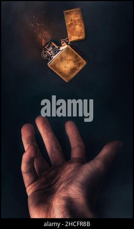 Vertical shot of a man's hand throwing up a metallic lighter while burning on a dark background Stock Photo