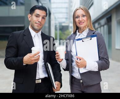Portrait of couple who are standing with folder and coffee Stock Photo