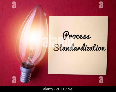 Process standardization written on sticky note with shinning light bulb. Business concept and ideas Stock Photo