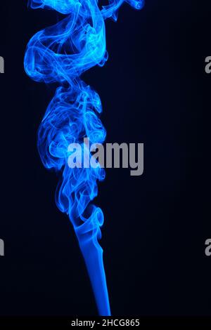 Jet of blue smoke on black background Stock Photo