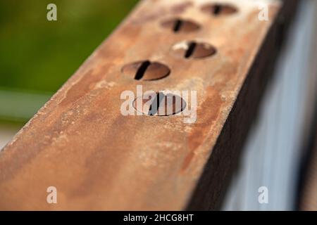 rusty screws on a bridge railing Stock Photo