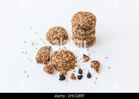 top view of a stack of oatmeal cookies, slices and cookie crumbs, raisins and flax and sesame seeds. healthy sweet dish Stock Photo