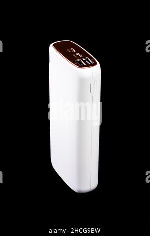 white power bank for charging smartphones and various digital devices on a black background close-up Stock Photo