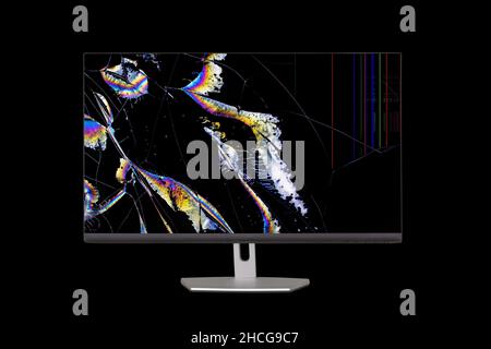 flowing crystals in the form of colored stripes and cracks on the broken screen of a liquid crystal display computer monitor  isolated on a black back Stock Photo
