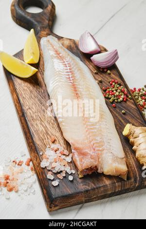 Freshly frozen zander fillet on wooden cutting board Stock Photo