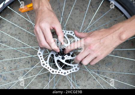 A man repairs a bicycle wheel. Replacement of bearings on the front wheel. Stock Photo