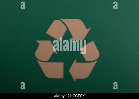 Closeup of the brown sign of recycling on the green paper. Eco-friendly concept. Stock Photo