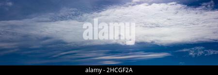 Blue sky with white clouds illuminated by the bright sun. Stock Photo
