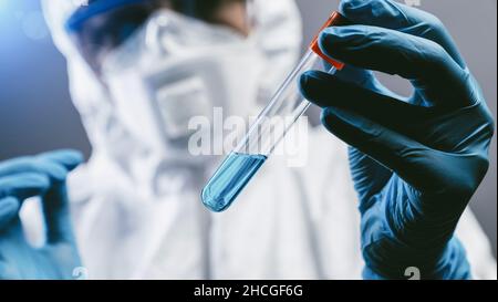 female medical or scientific researcher or woman doctor looking at 2019-nCoV Coronavirus Test tube. Positive Blood Sample. Coronavirus outbreaking Stock Photo