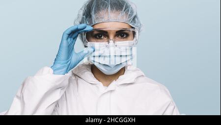 Female Doctor or Nurse Wearing latex protective gloves and medical Protective Mask and glasses on face. Protection for Coronavirus COVID-19 Stock Photo