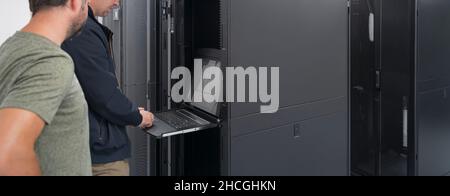 Technicians team updating hardware inspecting system performance in super computer server room or cryptocurrency mining farm. Stock Photo