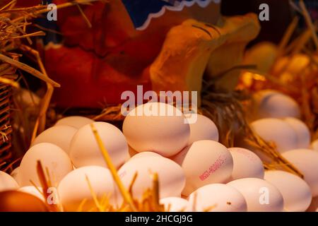Close-up shot of organic chicken eggs in a straw basket at the Boqueria market in Spain Stock Photo