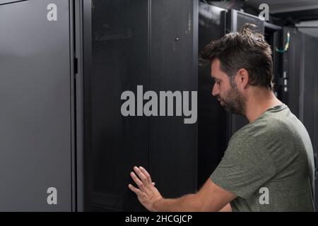 Technicians team updating hardware inspecting system performance in super computer server room or cryptocurrency mining farm. Stock Photo
