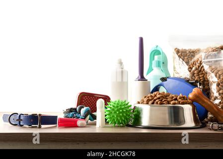 Food and accessories for walk, play and body care for the dog on wooden table isolated background Front view. Horizontal composition. Stock Photo