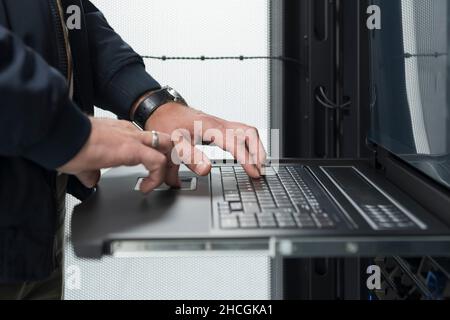 Close up on Data Center Engineer hands Using keyboard on a supercomputer Server Room Specialist Facility with Male System Administrator Working with Stock Photo