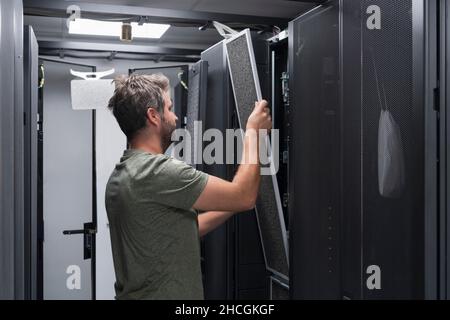 IT engineer working In the server room or data center The technician puts in a rack a new server of corporate business mainframe supercomputer or Stock Photo