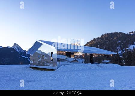 Schoenried, Switzerland - December 18, 2020: The Swiss Alps landscape reflected in blue hours on Mirage Gstaad by the American artist Doug Aitken Stock Photo
