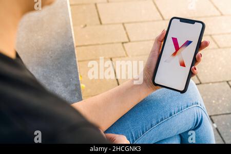 Woman hand holding iphone Xs with logo of the New Apple iPhone X smartphone. Stock Photo