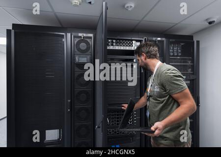 Data Center Engineer Usaing Keyboard on a Supercomputer Server Room ...