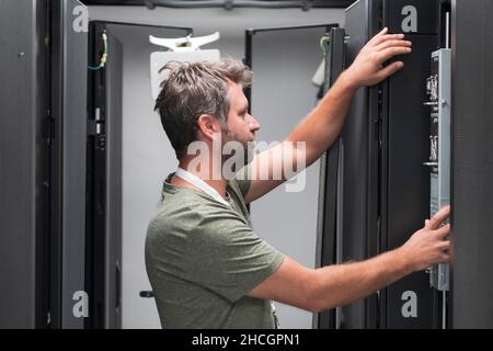 IT engineer working In the server room or data center The technician puts in a rack a new server of corporate business mainframe supercomputer or Stock Photo