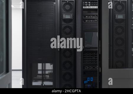Data Center With Multiple Rows of Fully Operational Server Racks. Modern Telecommunications, Cloud Computing, Artificial Intelligence, Database Stock Photo