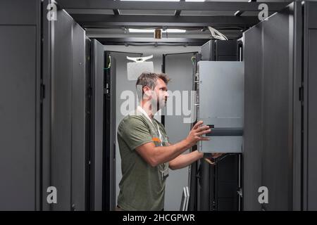 IT engineer working In the server room or data center The technician puts in a rack a new server of corporate business mainframe supercomputer or Stock Photo