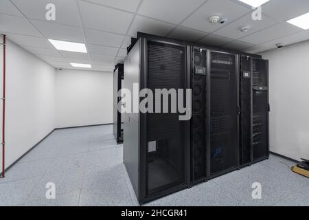 Data Center With Multiple Rows of Fully Operational Server Racks. Modern Telecommunications, Cloud Computing, Artificial Intelligence, Database Stock Photo