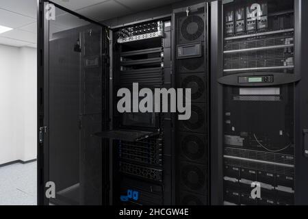 Data Center With Multiple Rows of Fully Operational Server Racks. Modern Telecommunications, Cloud Computing, Artificial Intelligence, Database Stock Photo