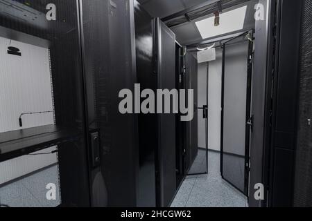 Data Center With Multiple Rows of Fully Operational Server Racks. Modern Telecommunications, Cloud Computing, Artificial Intelligence, Database Stock Photo