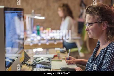 Business woman accountant designer works on computer in working office. Corporate person in technology company. Real life concept Stock Photo
