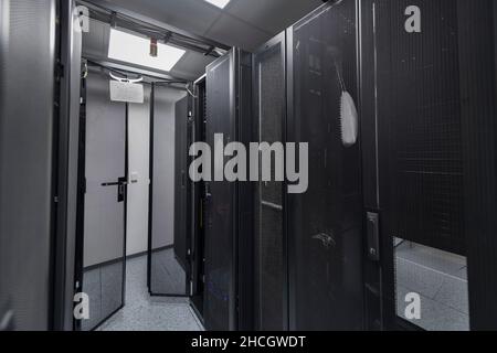 Data Center With Multiple Rows of Fully Operational Server Racks. Modern Telecommunications, Cloud Computing, Artificial Intelligence, Database Stock Photo