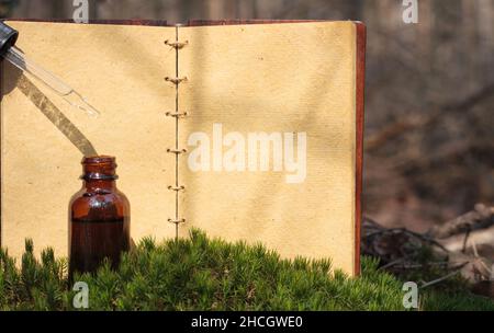 Concept related to natural medicine. Bottle with dropper and old notebook. Space for text. Stock Photo