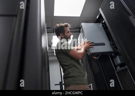 IT engineer working In the server room or data center The technician puts in a rack a new server of corporate business mainframe supercomputer or Stock Photo